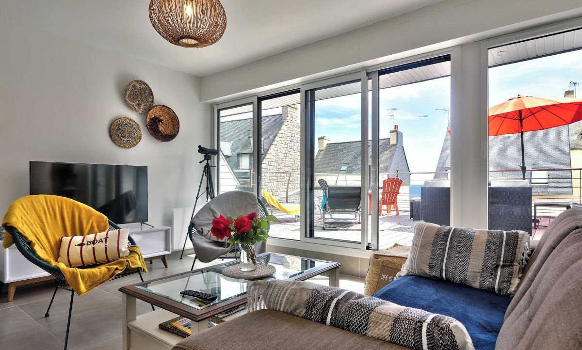 Un salon moderne avec un canapé, un fauteuil et une table basse en verre.