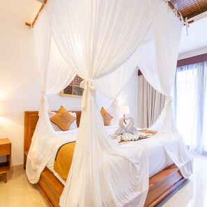 A four-poster canopy bed with a wooden headboard and a nightstand. - Villa Sonia Bisma (Ubud)