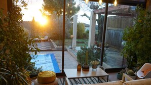 A cozy patio area with a sofa, cushions, a small table, and potted plants. - Family villa between sea and scrubland 15 min Mtp (Combaillaux)