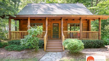 Welcome to this charming cabin with a cozy front porch and beautifully maintained surroundings.