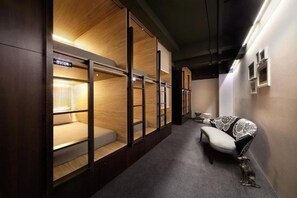 A hallway with bunk beds, a bench, and a small table with a decorative item.