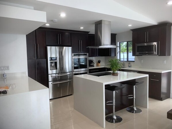Enjoy cooking in this well-equipped kitchen with a refrigerator, oven, and microwave, plus a central island for casual dining.