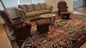 A living room with a beige sofa, two brown armchairs, a coffee table, and a patterned rug. -  EZ - GO Lodging 3.7 mi Green Pond Landing(Lake Hartwell) Clemson Univ 15 mil. (Anderson)