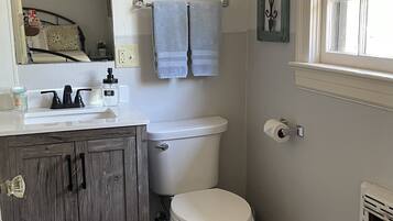 Een bad/douchecombinatie, een haardroger, handdoeken, zeep