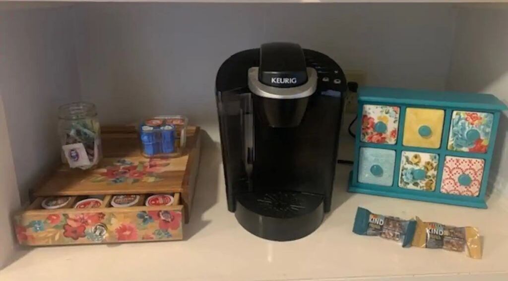 Une machine à café, un bocal de thé, une boîte de mouchoirs et une petite boîte compartimentée.