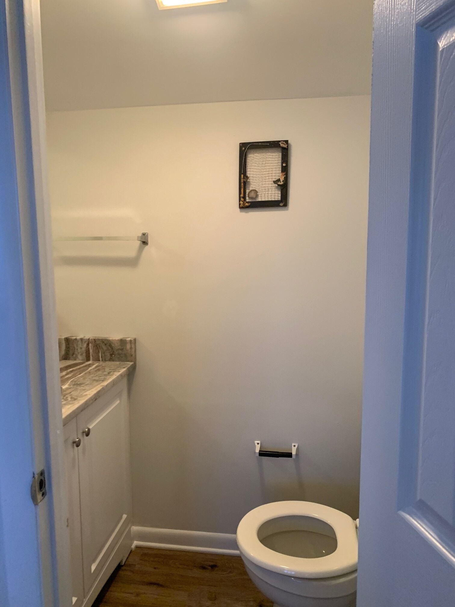 Een kleine badkamer met toilet, douche en een wastafel met een marmeren blad.