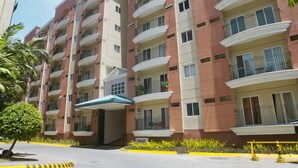 A multi-story residential building with balconies, a covered entrance, and a clear sky. - Chateau Elysee Seine Cluster (Parañaque)