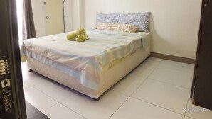 A hotel room with a bed, a painting on the wall, and a door. - Chateau Elysee Seine Cluster (Parañaque)