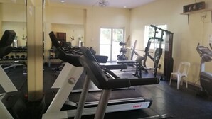 A gym with treadmills, weight machines, and a mirrored wall. - Chateau Elysee - Seine Cluster (Parañaque)