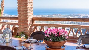 Taula preparada per dinar amb vista a l'oceà i al perfil urbà.
