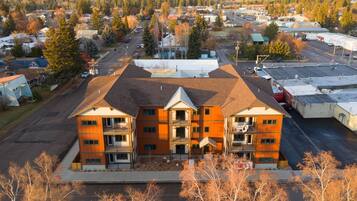 A multi-story building with a central courtyard and a parking lot in the foreground.