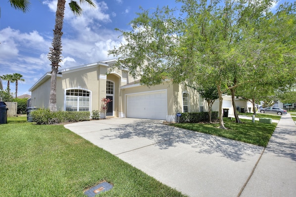 A residential house with a garage, a lawn, and a sidewalk.
