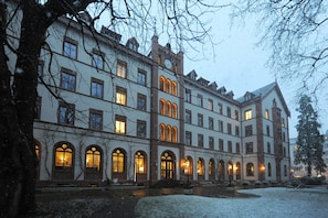 A large, historic building with multiple arched windows and a central clock tower. - TOP Hotel Odelya (Basel)