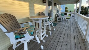 A wooden deck with white furniture, including chairs and a table.