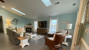 A spacious living room with a fireplace, comfortable seating, and a television.