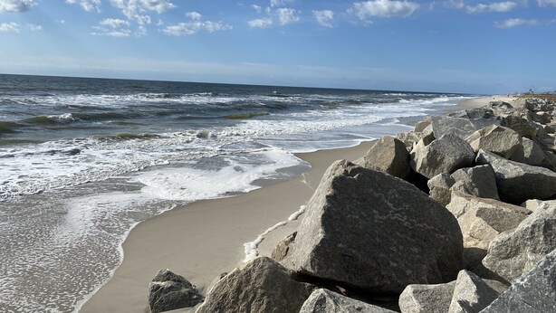 A rocky beach with waves crashing onto the shore.