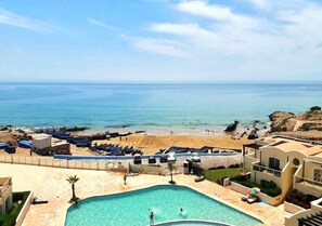 Ein Poolbereich mit Blick auf Strand und Meer.