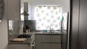 A compact kitchen with a gas stove, sink, and a refrigerator. - Close to the Beach! (Punta Cana)