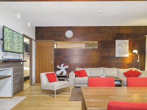 Un salon moderne avec un canapé, une table basse et un téléviseur.