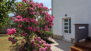 Ein Gebäude mit weißer Fassade, einer Glastür und einer kleinen Veranda mit Stufen.