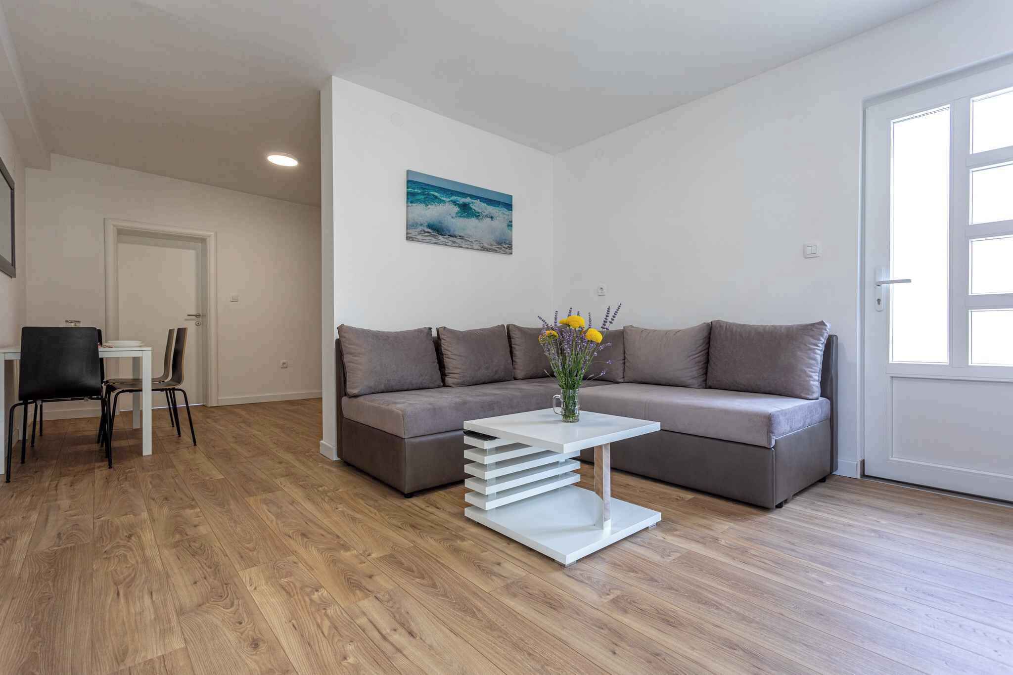 Ein modernes Wohnzimmer mit einem grauen Sofa, einem weißen Couchtisch und einem Gemälde an der Wand.