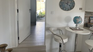 Une cuisine avec une horloge, un globe terrestre et une porte donnant sur un jardin.