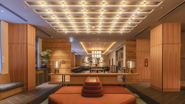 A modern hotel lobby with a central seating area, wooden paneling, and a ceiling with recessed lighting. - Hotel Forza Osaka Namba Dotonbori (Osaka)