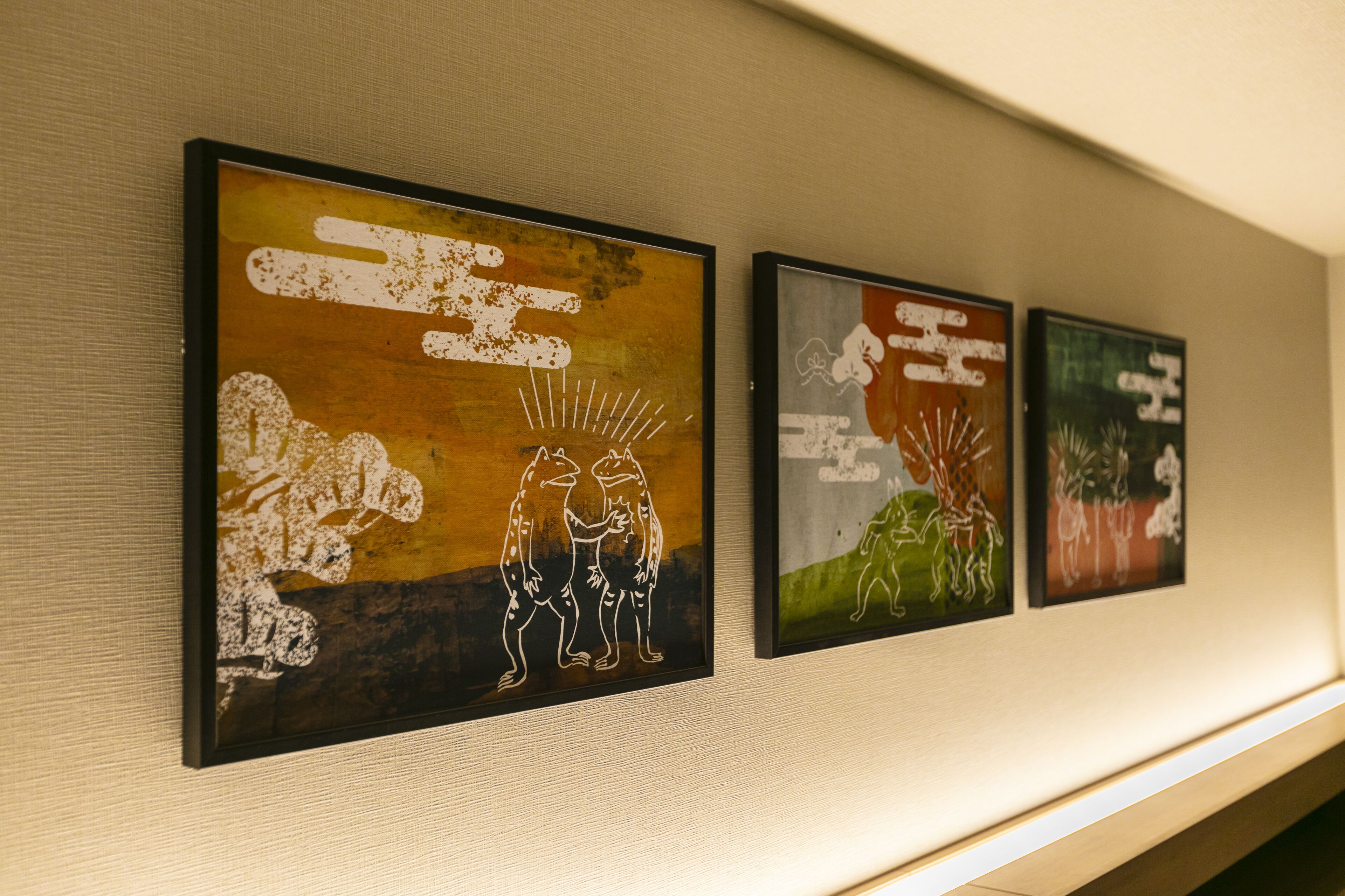 Three framed artworks on a wall.
