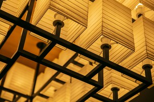 A ceiling with geometric patterns and structural beams.