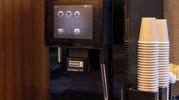 A coffee machine with a digital display, a branded coffee cup holder, and a branded coffee machine.