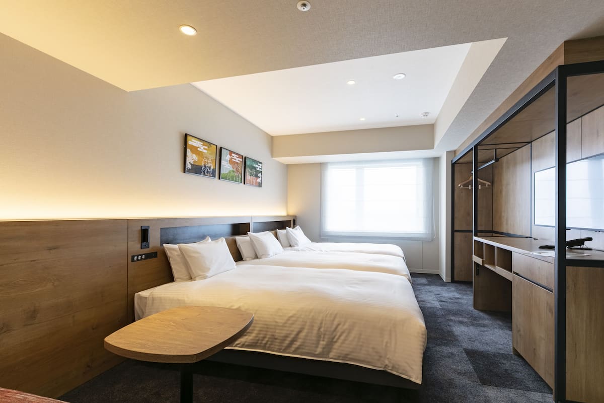 Una habitación de hotel con una cama grande, un escritorio y un armario.
