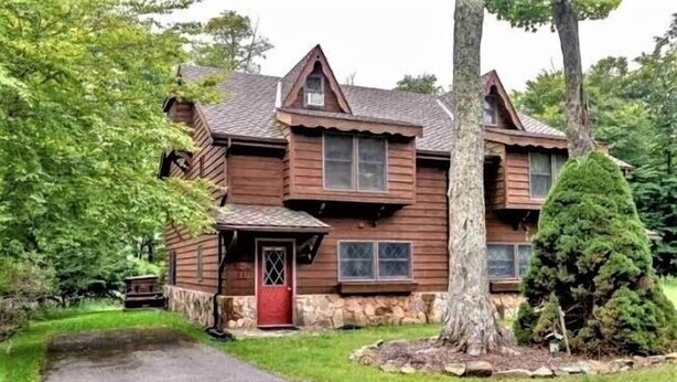 A wooden cabin with a stone foundation, a red door, and a stone chimney. - CPE1-Lovely Chalet! A/C, Pets Ok! (Davis)