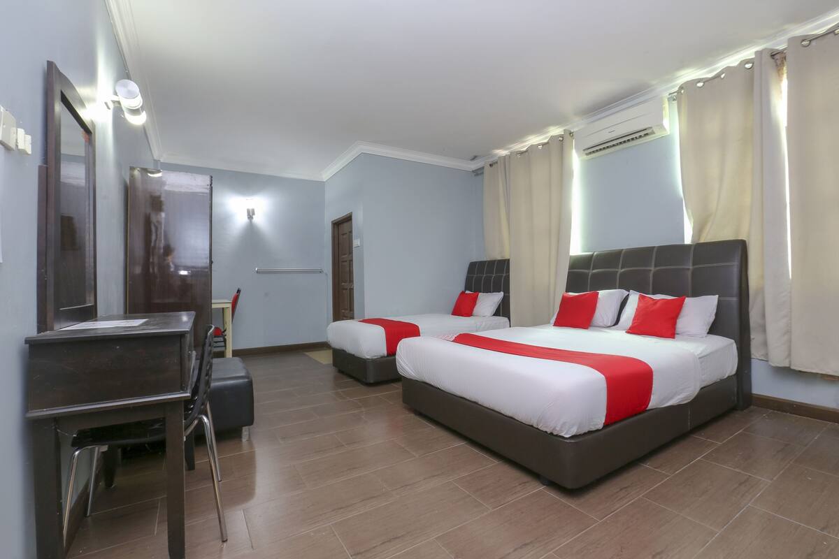 Una habitación de hotel con dos camas, un escritorio y una silla.