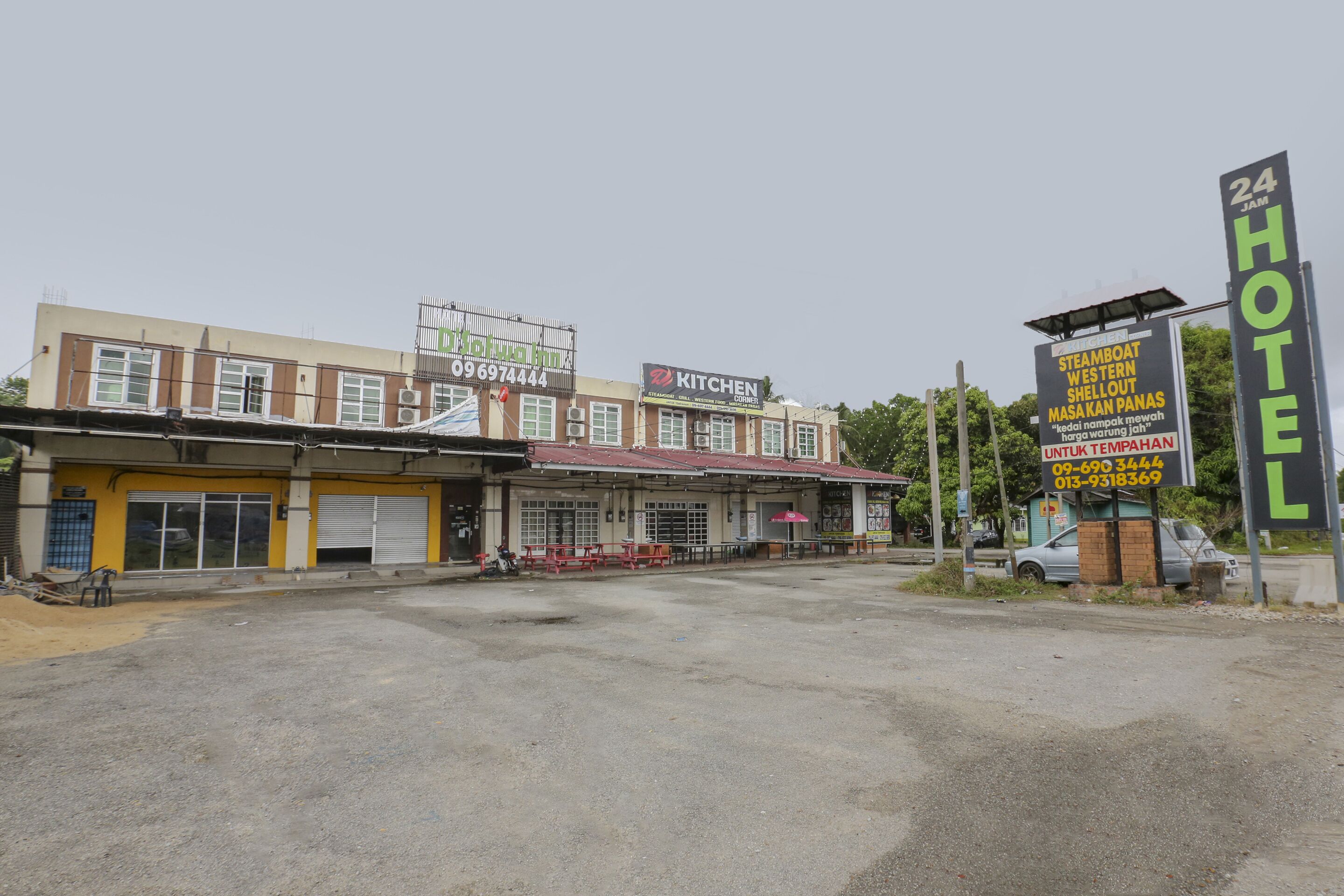 A building with multiple signs, including a prominent "24 Hotel" sign, a "Kitchen" sign, and a "Steamboat" sign.