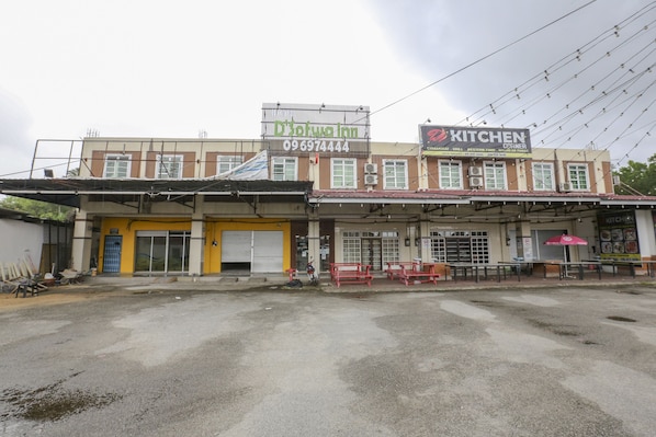 Kadun toisella puolella on rakennus, jossa on kyltti, jossa lukee «Herkkupuoti» ja «Keittiö».