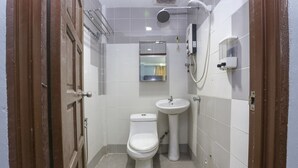 A small, clean bathroom with a toilet, sink, and shower.
