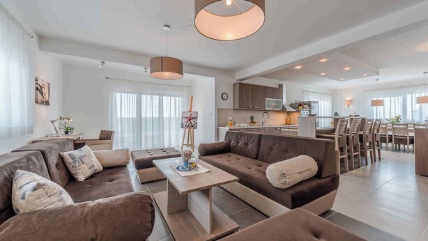 A modern living room with a sectional sofa, a coffee table, and pendant lighting. - Villa with pool, WiFi and air conditioning (Debeljak)