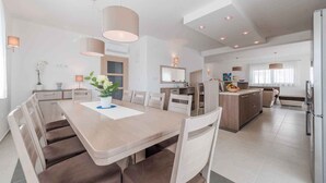 A modern kitchen with a central island, built-in appliances, and pendant lighting. - Villa with pool, WiFi and air conditioning (Debeljak)