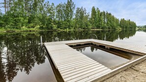 A wooden dock extending into a calm lake surrounded by dense forest. - Vacation home Koivu by Interhome (Sonkajärvi)