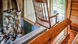 A wooden bench and a metal fireplace with logs. - Vacation home Koivu by Interhome (Sonkajärvi)