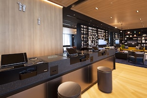 A reception area with a counter, seating, and a bookshelf.