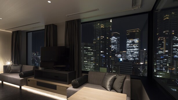 A modern living room with a large window, a flat-screen TV, and a sofa. - Hotel Intergate Osaka Umeda (Osaka)