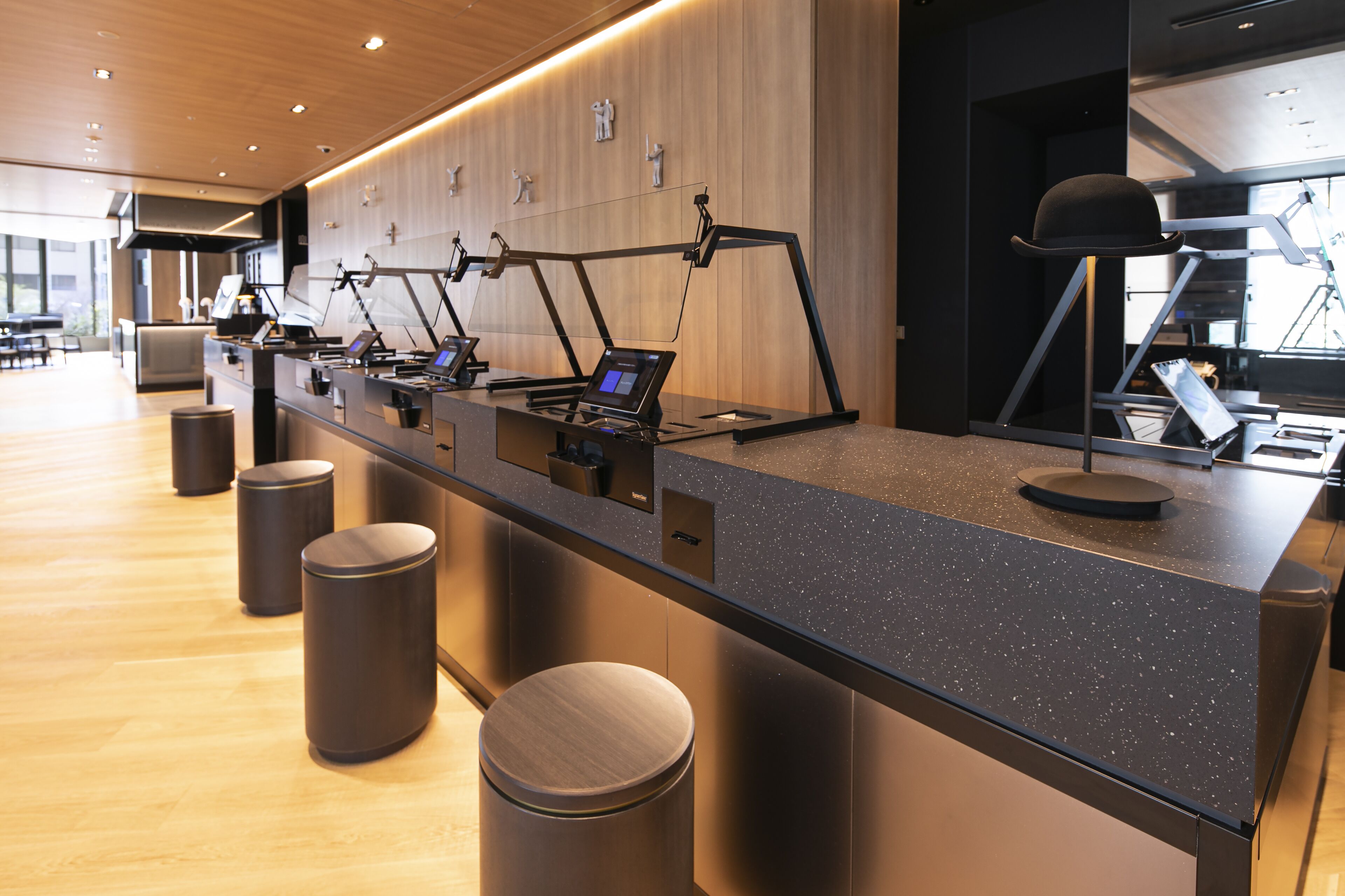 A modern reception desk with a sleek design, equipped with multiple computer stations and a large screen.