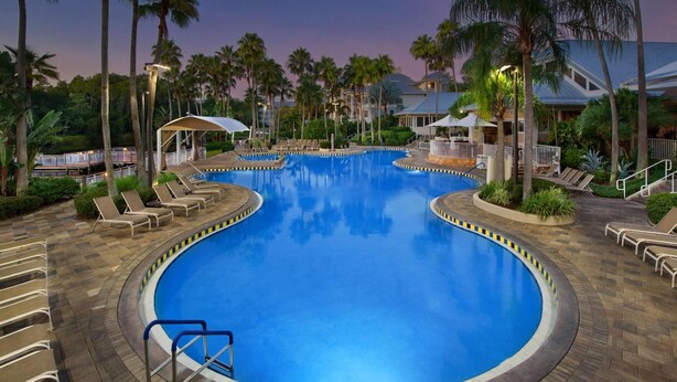 A large indoor swimming pool with multiple lounge areas and palm trees. - 2 BR at Marriott Cypress Harbour (Orlando)