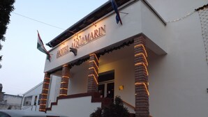 A hotel named "HOTEL AQUARIUM" with a signboard, brick pillars, and a car parked in front. - Aquamarin Hotel (Hévíz)