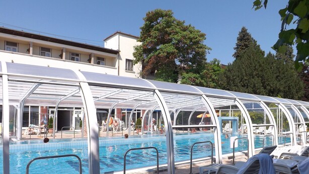 A pool area with a covered seating area and lounge chairs. - Aquamarin Hotel (Hévíz)