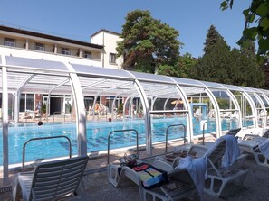 A pool area with a covered seating area and lounge chairs. - Aquamarin Hotel (Hévíz)