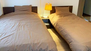 A double bed with a wooden headboard, a nightstand with a lamp, and a wooden floor. - Platinum Yasaka (Kyoto)