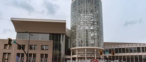 A modern building with a cylindrical glass tower and a flat-roofed section.