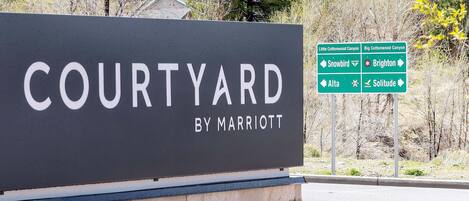 Een bord met 'Courtyard by Marriott' en pijlen naar nabijgelegen locaties.